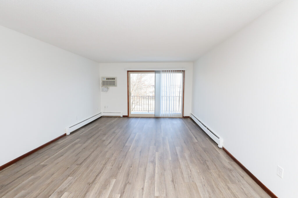 unfurnished living area with wood-style vinyl flooring and large patio glass sliding door